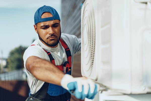 young-black-man-repairman-checking-an-outside-air-conditioner-unit-1536x1024